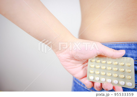 後ろ手に経口避妊薬(低用量ピル)を持つ女性 後ろ手に経口避妊薬(低用量ピル)を持つ女性 95533359