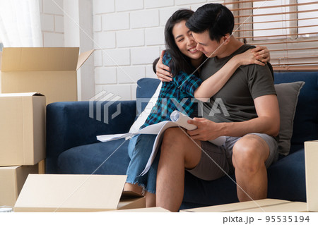 Smiling young Asian happy couple hold blueprint for home decoration ideas at moving day in their new home after buying real estate. Concept of starting a new life for a newly married couple. Smiling young Asian happy couple hold blueprint for home decoration ideas at moving day in their new home after buying real estate. Concept of starting a new life for a newly married couple. 95535194