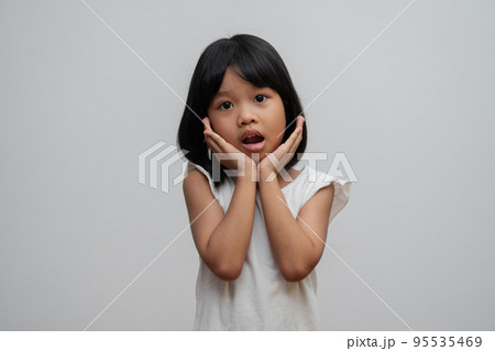 Portrait of Asian child 5 year old and to collect hair and Place her hands on her chin and make thinking pose on isolated white background, She is Happiness, radiance in youth, Education Concept 95535469