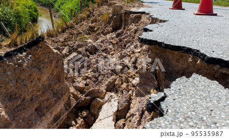 Landslide caused by rains occurs broken road asphalt.  95535987