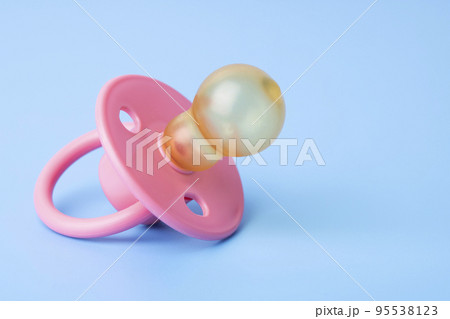 Orthodontic pacifier on a blue background. Pink baby pacifier 95538123
