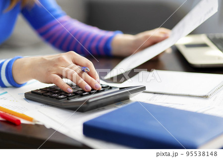 Woman using using calculator for calculate home finances or car taxes Woman using using calculator for calculate home finances or car taxes 95538148