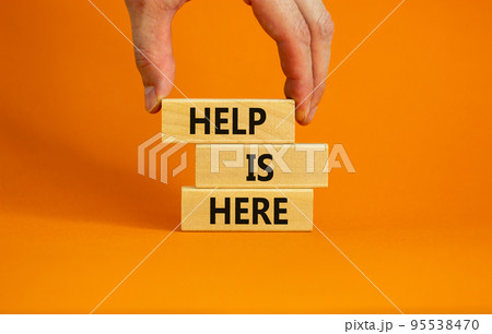 Help is here symbol. Wooden blocks with words 'Help is here' on beautiful orange background. Businessman hand. Business, support, help is here concept. Copy space. Help is here symbol. Wooden blocks with words 'Help is here' on beautiful orange background. Businessman hand. Business, support, help is here concept. Copy space. 95538470