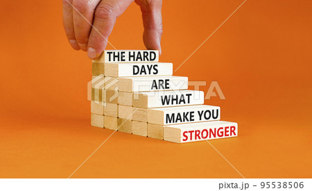 Support and be stronger symbol. Concept words The hard days are what make you stronger on wooden blocks. Bussinesman hand. Beautiful orange background. Business and be stronger concept. Copy space. 95538506