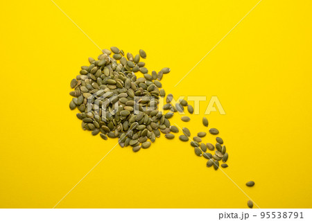 Pumpkin seed on a yellow background close-up. 95538791