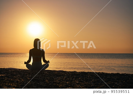 Silhouette young woman practicing yoga on the beach at sunset, Karon Beach ,Phuket ,Thailand. For Silhouette young woman practicing yoga on the beach at sunset, Karon Beach ,Phuket ,Thailand. For 95539551