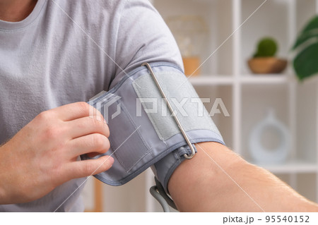 A man measures blood pressure with a white 95540152