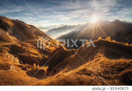 Mountains in low clouds at beautiful sunset in autumn in Italy 95540875