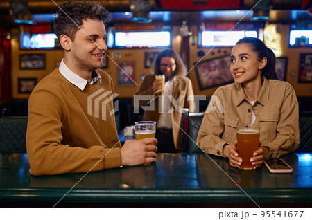 Young couple flirting and drinking beer in bar 95541677