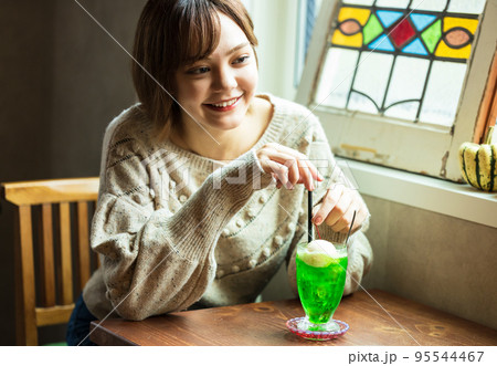 カフェでメロンソーダを飲む可愛い女性 カフェでメロンソーダを飲む可愛い女性 95544467