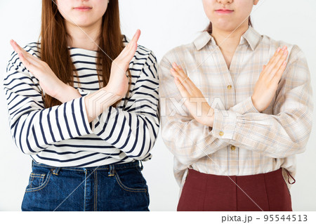 バツをして拒否する若い女性二人 95544513
