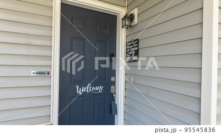 Panorama Blue front door of a house with white welcome calligraphy at the front 95545836