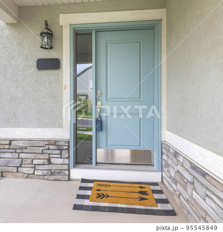 Square Light blue front door with lockbox and doormat on a concrete entrance Square Light blue front door with lockbox and doormat on a concrete entrance 95545849