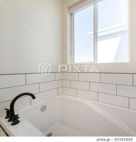 Square Alcove bathtub with white subway tiles surround with black grout Square Alcove bathtub with white subway tiles surround with black grout 95545884