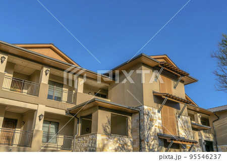 Austin, Texas- Apartment building facade with brown color scheme and balconies near Lake Austin 95546237