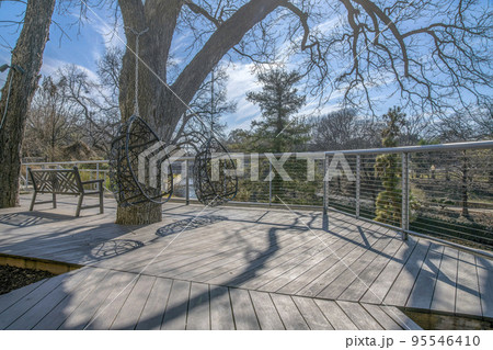 Wooden walkway with swings and bench at the San Antonio River Walk in Texas 95546410