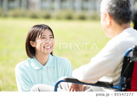 笑顔で働く介護士・車椅子の男性と会話する女性介護士 笑顔で働く介護士・車椅子の男性と会話する女性介護士 95547277