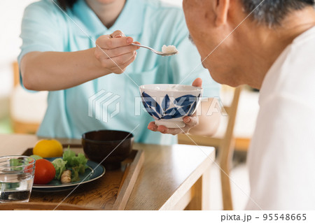 シニアにご飯を食べさせる介護士 95548665
