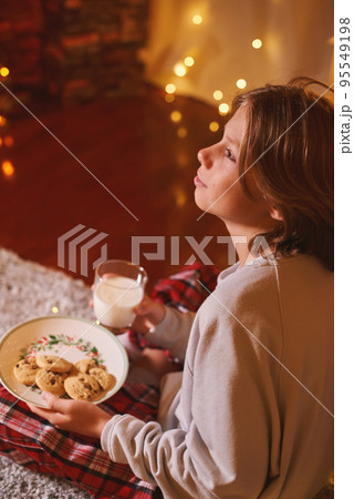 Cute boy ready for Santa Claus waiting with cookies and milk. Belief in fairy tale 95549198
