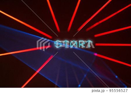 Dark background with red laser beams and text Start. Dark background with red laser beams and text Start. 95556527