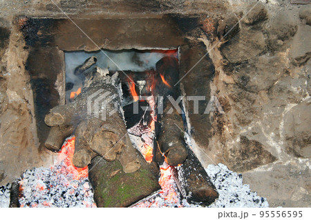 炭焼き窯の釜口で雑木が赤く燃えている 95556595
