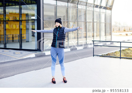 Pretty athletic woman training in the park alone. Woman doing warm-up in nature Pretty athletic woman training in the park alone. Woman doing warm-up in nature 95558133