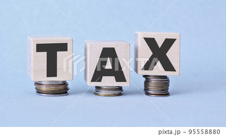 Tax concept with wooden blocks and coins on table Tax concept with wooden blocks and coins on table 95558880