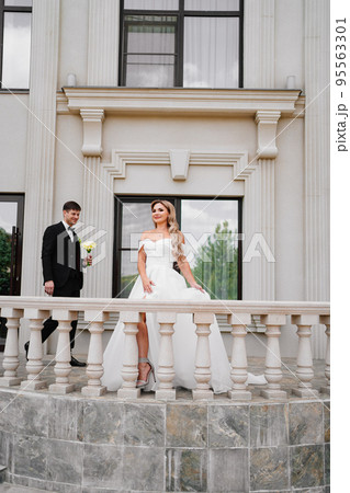 Beautiful bride and groom blonde on the balcony of a classic building. Beautiful bride and groom blonde on the balcony of a classic building. 95563301