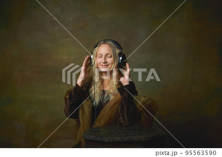 Soul music. Vintage style portrait of young charming girl in image of Mona Lisa, La Gioconda isolated on dark green background. Art, beauty, style, imitation Soul music. Vintage style portrait of young charming girl in image of Mona Lisa, La Gioconda isolated on dark green background. Art, beauty, style, imitation 95563590