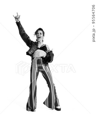 Portrait of beautiful young woman, rock music lover posing, dancing isolated over white background. Black and white photo 95564706
