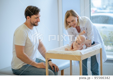 Pediatric doctor testing the newborn baby reflexes Pediatric doctor testing the newborn baby reflexes 95566382