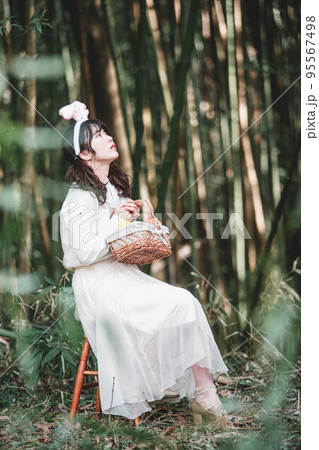 森の中で白いワンピースを着ているウサギ姿の女性 95567498