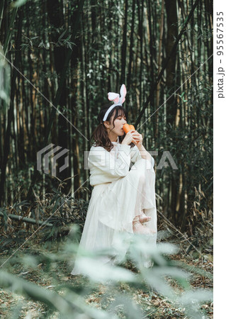 森の中で白いワンピースを着ているウサギ姿の女性 95567535
