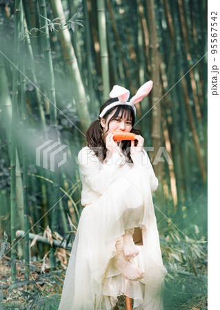 森の中で白いワンピースを着ているウサギ姿の女性 95567542