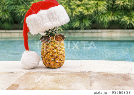 Funny pineapple wearing sunglasses and Santa...の写真素材