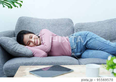 Portrait of a beautiful Asian teen girl relaxing on the sofa at home. Portrait of a beautiful Asian teen girl relaxing on the sofa at home. 95569570