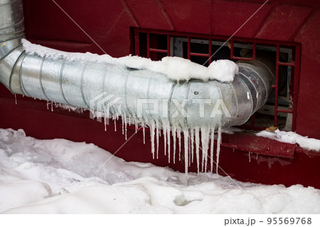 Galvanized heating pipe covered with icicles in winter, heating of non-residential premises Galvanized heating pipe covered with icicles in winter, heating of non-residential premises 95569768