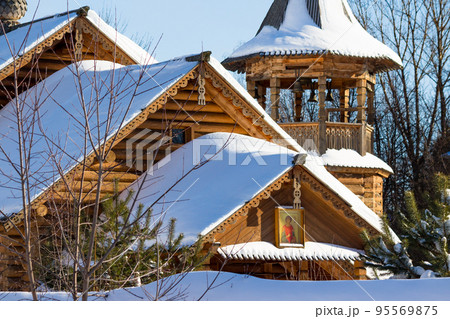 View of a snow-covered wooden Russian Orthodox Church, made in a traditional style, winter landscape View of a snow-covered wooden Russian Orthodox Church, made in a traditional style, winter landscape 95569875