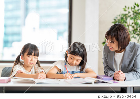 教室で勉強をする小学生と先生。 95570454