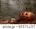 Glittering Halloween pumpkin in autumn leaves on wooden background 95571137