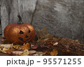 Glittering Halloween pumpkin in autumn leaves on wooden background. Seasonal compostion 95571255