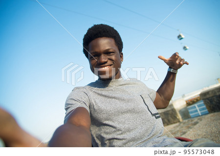 Beaming African American man having walk on summer day 95573048