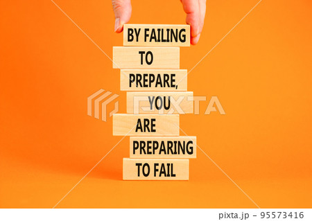 Preparing symbol. Concept words By failing to prepare you are preparing to fail on wooden blocks on a beautiful orange background. Businessman hand. Business motivational and preparing concept. Preparing symbol. Concept words By failing to prepare you are preparing to fail on wooden blocks on a beautiful orange background. Businessman hand. Business motivational and preparing concept. 95573416