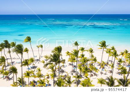 Bounty and pristine sandy shore with coconut palm trees, caribbean sea washes tropical coast. Arenda Gorda beach. Dominican Republic. Aerial view 95574417