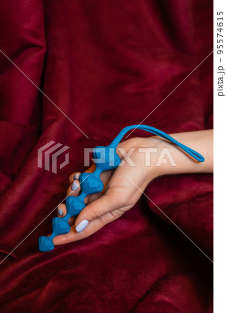 Woman holding anal balls in bed close-up. 95574615