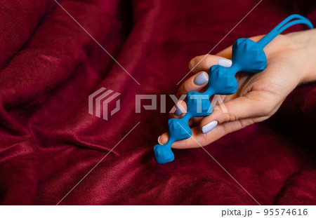 Woman holding anal balls in bed close-up. 95574616