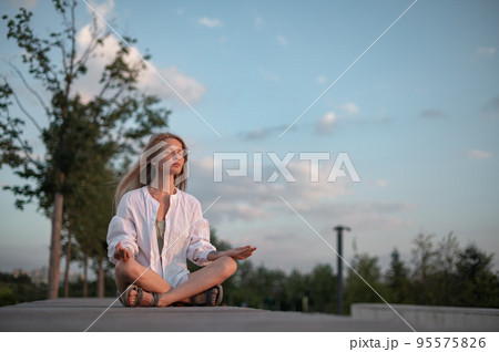 Girl practice yoga meditation outdoor in park 95575826