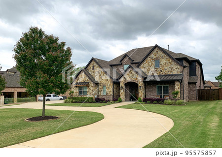 Door leading to big custom made luxury house with nicely landscaped and trimmed front yard with tree, neat lawn in front of the residential house. Door leading to big custom made luxury house with nicely landscaped and trimmed front yard with tree, neat lawn in front of the residential house. 95575857