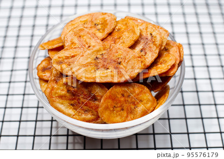 Banana chips on white background Banana chips on white background 95576179