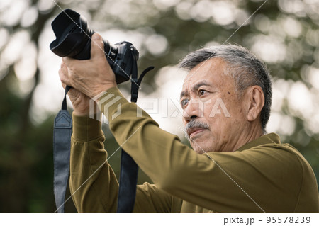 写真を撮るシニア男性 95578239